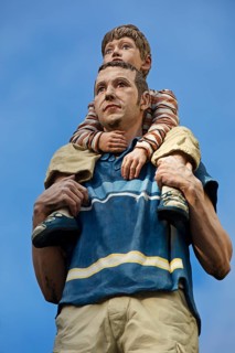 Realistic sculpture of a pillar saint father and son on a lift barrel pillar