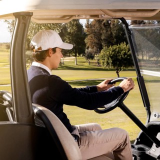 Side view man driving golf cart field