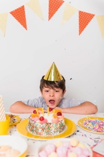 Birthday boy blowing out candles cake