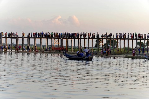 Locals and tourists on a teak bridge