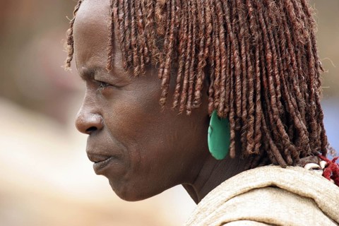 Close up portrait of woman of the Hamar tribe with traditional red headdress
