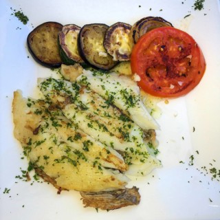 Mediterranean dish for healthy eating according to Italian recipe with sole Grilled sole fillet sprinkled with chopped parsley with lightly fried slices of aubergine Melanzane and tomato drizzled with...