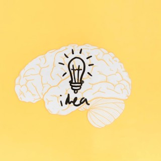 Idea word with light bulb inside brain yellow background