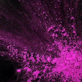 Pink dust particles splash against black background