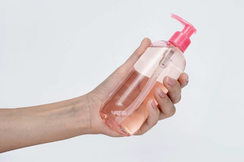 Side view person holding bottle liquid soap
