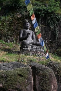Buddha statue and Tibetan prayer flags in front of the entrance to the Messner Mountain Museum near Bolzano