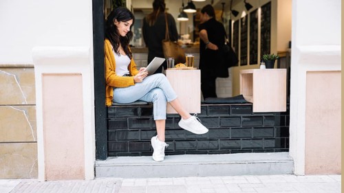 Woman sitting cafe table with tablet