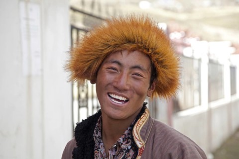 Close up portrait of smiling Tibetan man with fur hat in the village Qagca