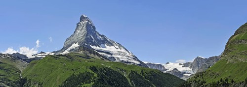 Panoramic view over the Matterhorn mountain with alpine meadows and pine forests in the Swiss Alps