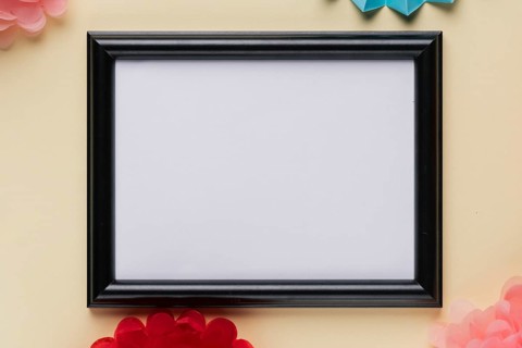 Elevated view white empty frame beige backdrop