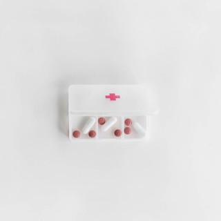 Overhead view white plastic pill organizer white background