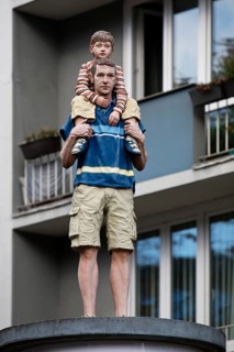 Realistic sculpture of a pillar saint father and son on a lift barrel pillar