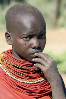 Portrait of young Turkana woman in traditional red clothing in northwest Kenya