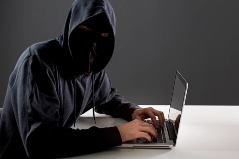 Side view male hacker with laptop