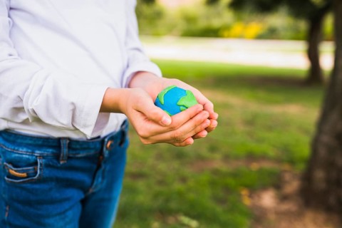 Midsection girl holding globe cupped hands
