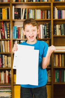 Happy boy showing paper with excellent mark