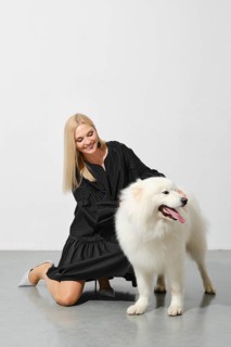 Happy blonde woman playing with her samoyed dog