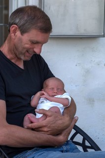 Young grandfather with his newborn grandson