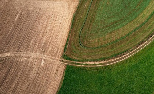 Drone view of green and ploughed fields with field path near Pabneukirchen