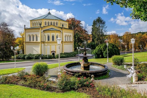 Fountain in front of the Church of the Assumption of Mary in the autumnal spa park