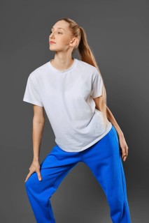 Young sportive woman bend forward over grey studio background