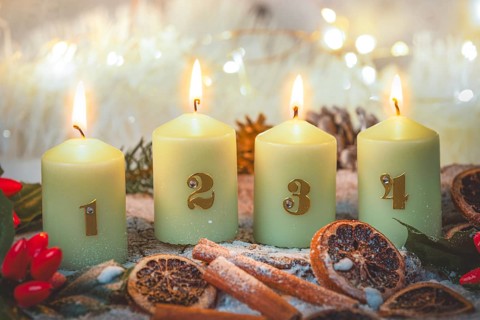 Advent candles surrounded by Christmas decorations