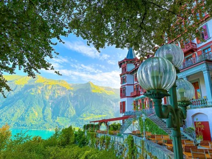 Grandhotel Giessbach with Terrace and Street Lamp and Mountain with Lake Brienz in a Sunny Summer Day in Brienz