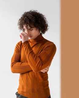 Curly man with brown blouse posing