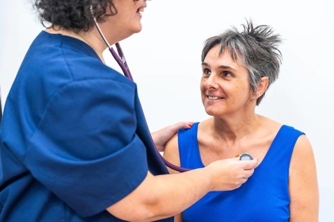 Cardiologist listening to the heartbeats of an older woman