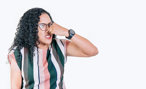 Afro woman covering her nose from a bad smell isolated. Displeased person holding her nose isolated. Disgust girl covering nose