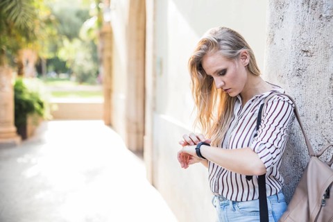 Close up blonde young woman checking her time watch