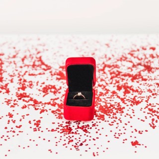 Jewellery box with ring near confetti