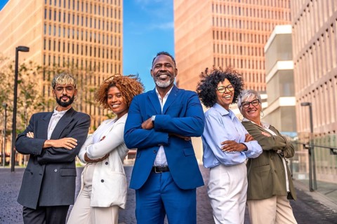Formal portrait of a multi-ethnic business team standing proud outdoors in the financial district