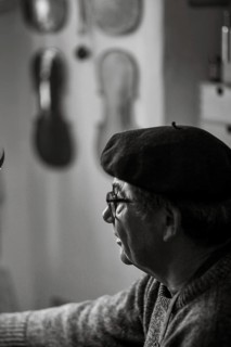 Portrait of senior violinmaker in workshop in Cremona