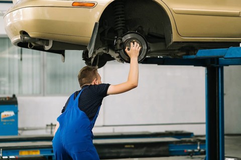 Auto mechanic holding hob car