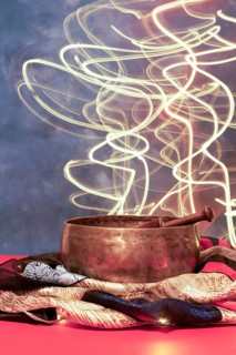 Tibetan singing bowl on colored cloth with moving led lights in the background