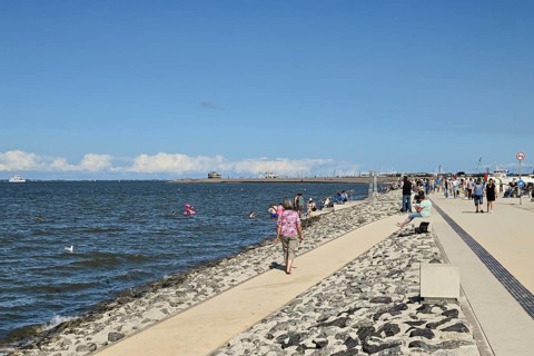 Concreted seashore with bathers