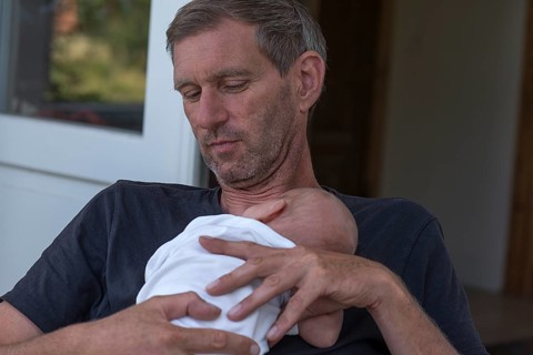 Young grandfather with his newborn grandson