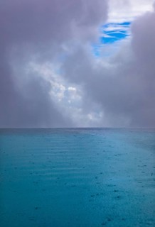 Rippled water surface during rain in swimming pool with dramatic cloudy sky