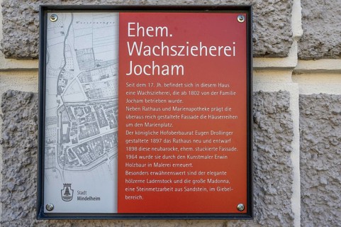 Information board about the former Jocham house with a statue of the Virgin Mary