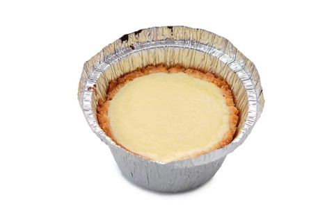 High angle view of vanilla cake in a baking foil dish isolated on white background