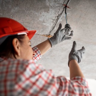 Low angle female construction worker with light bulb