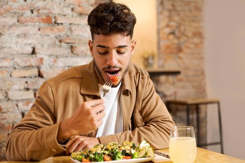 Medium shot man eating indoors