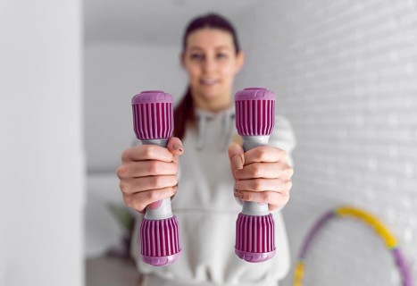 Medium shot woman holding dumbbells 2
