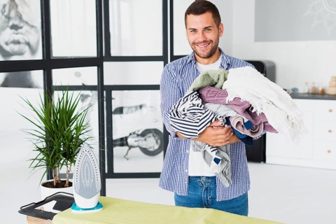High angle man holding stack clothes