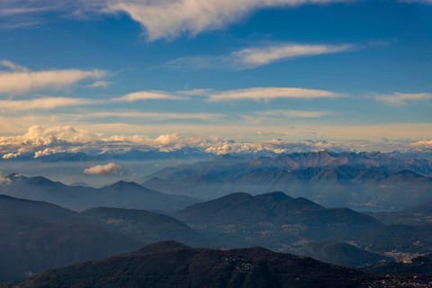 Aerial View over a Beautiful Mountainscape and And Snow Capped Mountain and with Floating Clouds in a Sunny Day in Ticino