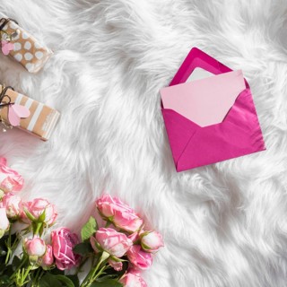 Envelope near gifts fresh flowers woolen coverlet