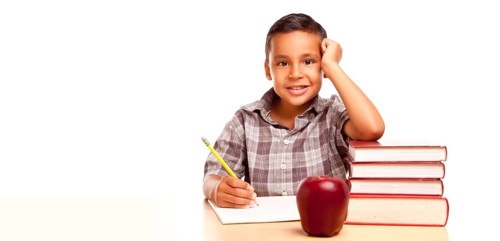 Happy young hispanic school boy at desk with books and apple isolated on a white background