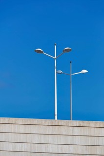 White street lamps against a blue sky