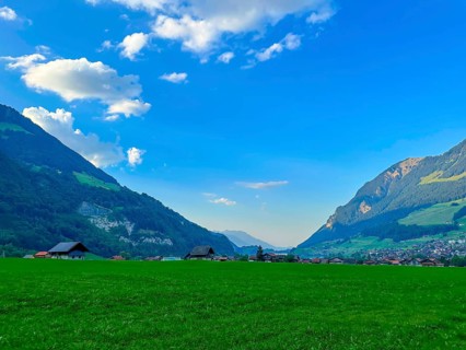 Beautiful Village in Mountain Valley with Blue Sky and Clouds in a Sunny Summer Day in Lungern